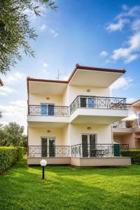 a large white house with a green yard at PROPERSTAY 112 - Maison Calme Polychrono in Polychrono