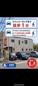 a street sign with cars parked in front of a building at エルビスコート井尻101号 in Morooka