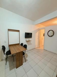 a room with a table and chairs and a tv at Apartamento Rua Teresa in Petrópolis +2 photos