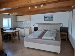 a bedroom with a bed and a kitchen with a table at Hotel & Restaurant Rössli in Seedorf