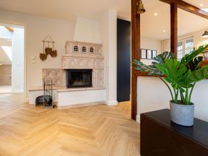 a living room with a fireplace and wooden floors at Villa Brunnenstraße, App 3 in Heringsdorf