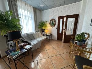 a living room with a couch and some plants at RoomRural Hotel Iru-Bide Lumbier in Lumbier