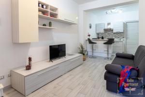 a living room with a flat screen tv and a couch at Italia Apartment in Catania