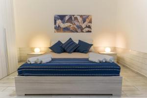 a bedroom with a large bed with blue pillows at Italia Apartment in Catania
