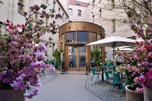 a restaurant with tables and chairs and purple flowers at AMO by AMANO Friedrichstrasse in Berlin