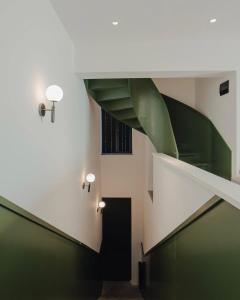 a spiral staircase in a building with a green at Artifact Apart Hotel in Tbilisi City +103 photos
