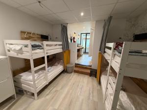 a room with three bunk beds and a kitchen at Spotsleeping in Anglet