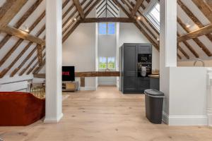 a kitchen in an attic with wooden beams at Modern & Historic Duplex Flat Riverside in Godalming +14 photos