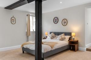 a bedroom with a bed and two clocks on the wall at Modern & Historic Duplex Flat Riverside in Godalming