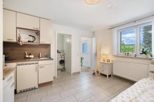 a kitchen with white cabinets and a sink at Gemütliche Einliegerwohnung in Gomadingen