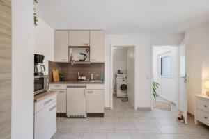 a kitchen with white cabinets and a tile floor at Gemütliche Einliegerwohnung in Gomadingen +18 photos