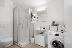 a white bathroom with a sink and a washing machine at Gemütliche Einliegerwohnung in Gomadingen