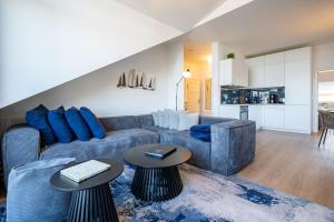 a living room with a blue couch and two tables at Villa Linquenda App 6 in Ahlbeck