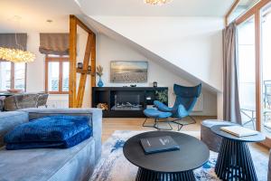 a living room with a blue couch and a fireplace at Villa Linquenda App 6 in Ahlbeck