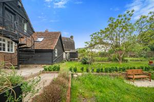 a garden with a bench in front of a house at Modern & Historic Duplex Flat Riverside in Godalming