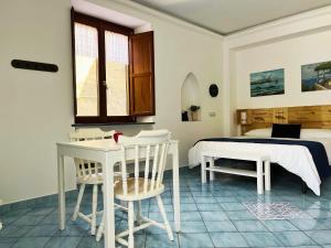 a bedroom with a bed and a table and chairs at Casa Tasca in Ravello