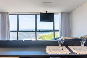 a dining room with a view of the ocean at BHS Flat a beira mar 2203 in Recife