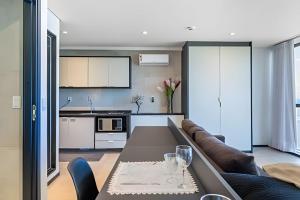 a kitchen and living room with a table and a couch at BHS Flat a beira mar 2203 in Recife