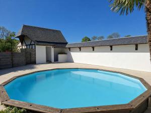 a large blue swimming pool in front of a house at Villa 1h30 de Paris - Padel - Piscine - 7 ch - 22 pers in Épinay