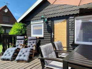 a group of chairs and a table on a deck at Ferienhaus Muckelbude in Bedekaspel