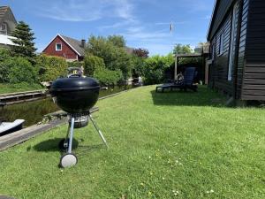 a grill sitting on the grass in a yard at Ferienhaus Muckelbude in Bedekaspel +23 photos