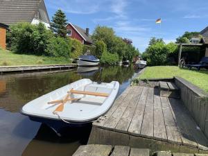 a small boat is docked at a dock at Ferienhaus Muckelbude in Bedekaspel