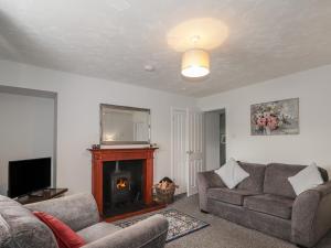 a living room with a couch and a fireplace at 3 Bruaich Cottages in Strathpeffer