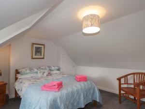 a bedroom with a bed with pink towels on it at 3 Bruaich Cottages in Strathpeffer