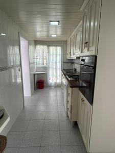 a kitchen with white cabinets and a tile floor at Thelma house Tossa in Tossa de Mar