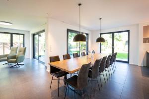a dining room with a large wooden table and chairs at Ferienhaus an der Küsteneiche in Koserow