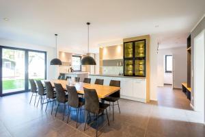 a kitchen and dining room with a wooden table and chairs at Ferienhaus an der Küsteneiche in Koserow