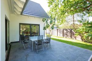 a patio with a table and chairs on it at Ferienhaus an der Küsteneiche in Koserow