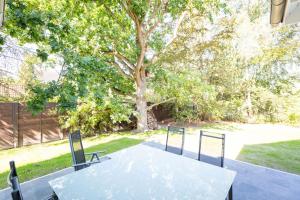 a table and chairs sitting in a yard with a tree at Ferienhaus an der Küsteneiche in Koserow +73 photos