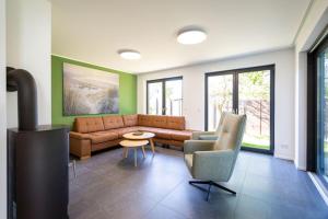 a living room with a couch and a table and chairs at Ferienhaus an der Küsteneiche in Koserow