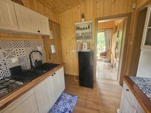 a kitchen with a stove and a sink and a refrigerator at HomeWood - Popowo Letnisko in Gąsiorowo Duże