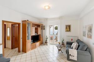 a living room with a couch and a tv at Ulivello House Sea View in Massa Lubrense
