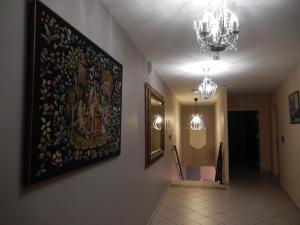un pasillo con una pintura en la pared y una lámpara de araña en Logis Hotel du Chemin des Dames en Corbeny