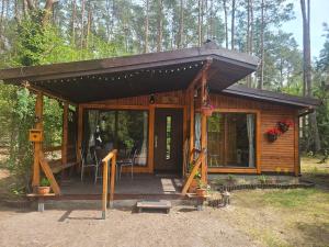 a wooden cabin with awning in the woods at HomeWood - Popowo Letnisko in Gąsiorowo Duże +21 photos