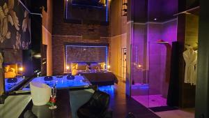 a bedroom with a bed with purple lighting and a dressing room at Suite avec Jacuzzi - Clim - Terrasse - Wi-Fi in Agde