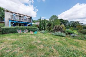 two umbrellas sitting on the grass in front of a house at Gite Douceur de vivre in Saint-Avaugourd-des-Landes