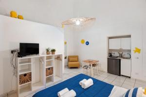 a living room with a blue bed and a kitchen at Casa Vacanza Sunshine in Meta