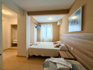 a bedroom with two beds and a window at Pension El Parque in Calpe