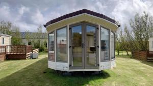 a small house sitting in the middle of a yard at Sandpiper Aspen 9 in Peterhead