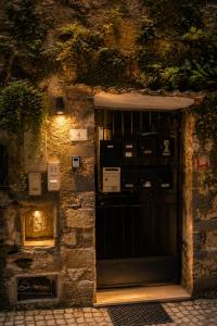 a stone building with a black door with a light at Vicolo delle Belle Suite in Terracina