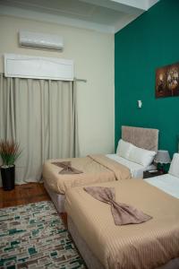 a room with three beds and a green wall at Cairo Center in Cairo