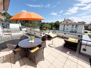 a patio with a table and chairs and an umbrella at Haus Meeresblick A 2 12 BLU in Baabe