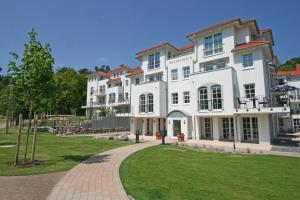 a large white building with a walkway in front at Haus Meeresblick A 2 12 BLU in Baabe +40 photos