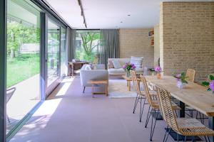 a living room with a long wooden table and chairs at B&B Hof Van Straeten in Jabbeke