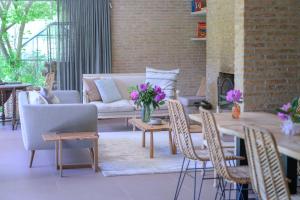 a living room with a couch and a table and chairs at B&B Hof Van Straeten in Jabbeke +32 photos
