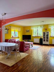 a living room with yellow walls and a table and chairs at Domek Gierczyn 16 in Gierczyn